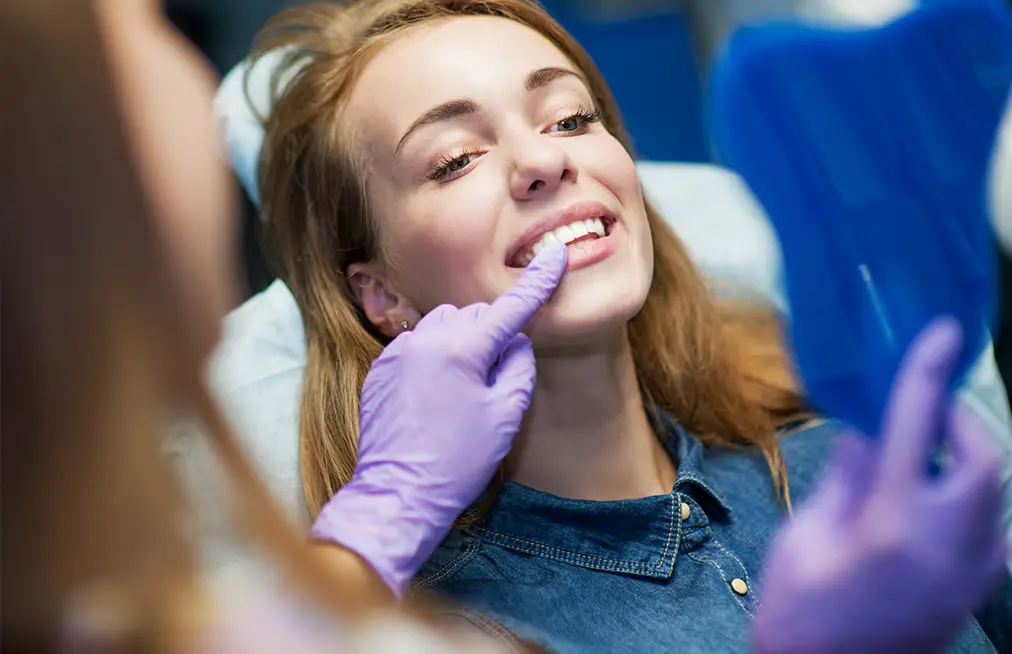 woman checking dental crown teeth